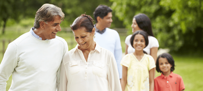 Happy multi-generational family of 6 walking in a park together