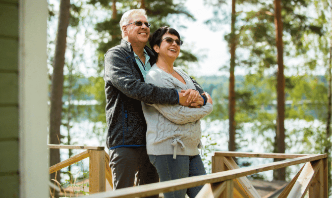 Happy older couple embracing on their porch