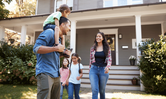 Young family of four outside their new home