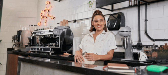 Cafe owner smiling at counter