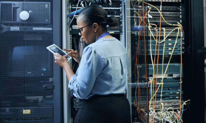 Professional woman troubleshooting in a computer server room