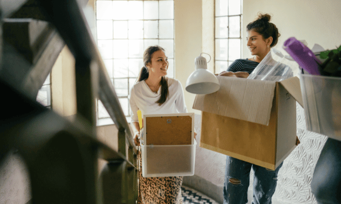 Two young college students moving into their dorm