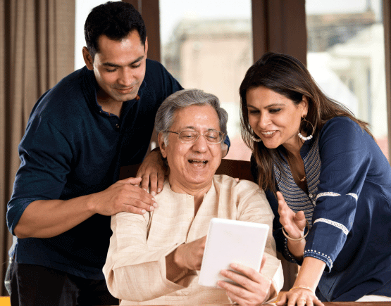 Older man looking at a tablet with his adult children