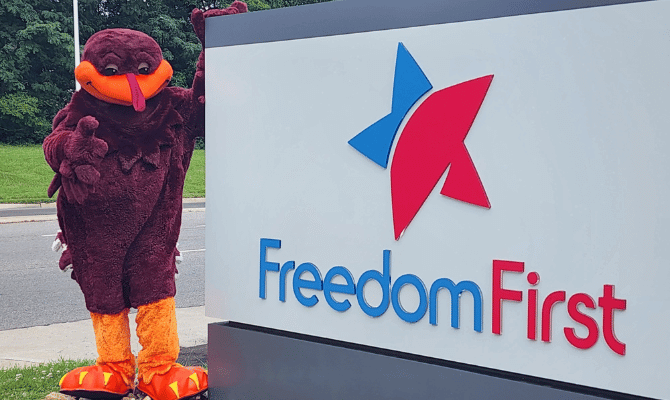 Hokie bird posing next to Freedom First sign