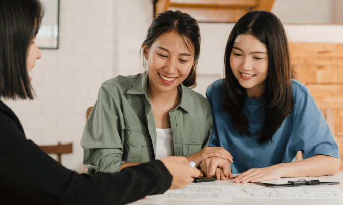 Young couple reviewing floor plans with their realtor